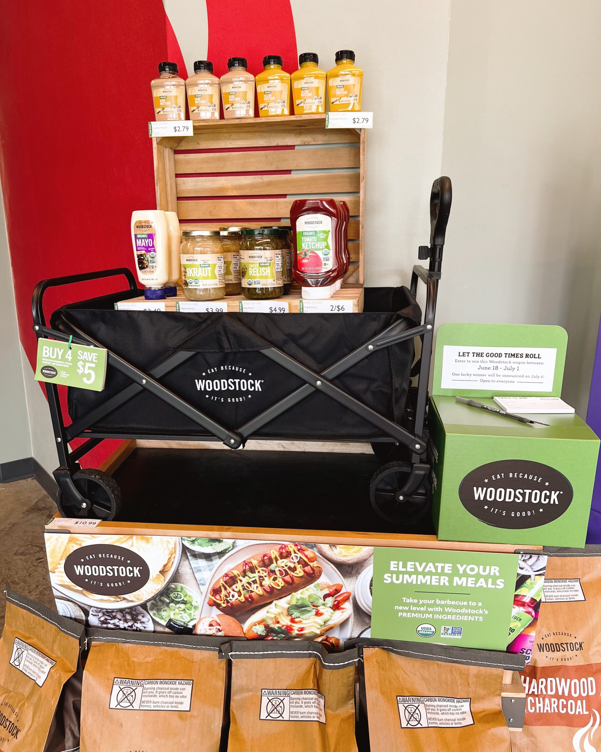 Black Woodstock wagon with picnic condiments like mayo, mustard, and ketchup surrounding it. A green raffle box is to the right.