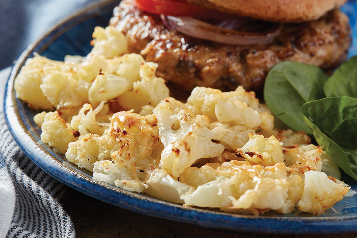 Cauliflower shines when it hits the high heat of the oven and becomes tender and sweet. These smashed florets are even better with a crispy crust of parmesan cheese.